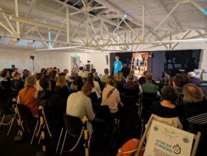 Public attentif lors de l'introduction de la pièce de théâtre